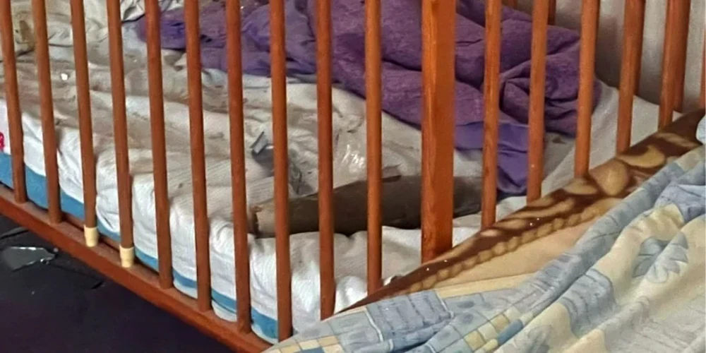 Наслідки падіння боєприпасу з дрона у приватному будинку в Херсоні, ліжечко та інтер'єр кімнати (фото Національної поліції